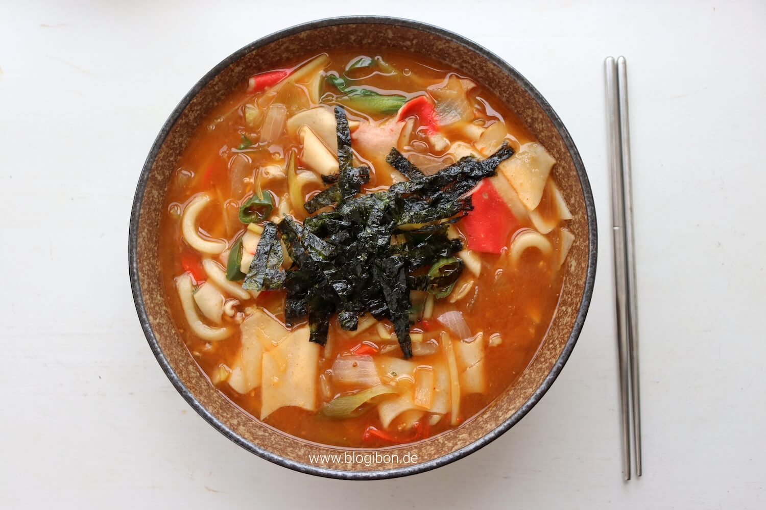 Scharfe Nudelsuppe namens Jang Kalguksu - Kalguksu Nudeln mit koreanischer Suppenbrühe, gochujang, deonjang, Gemüse und Sojasoße